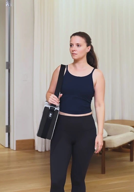A practitioner carrying the Bento Yoga ONE over her shoulder on the way to practice