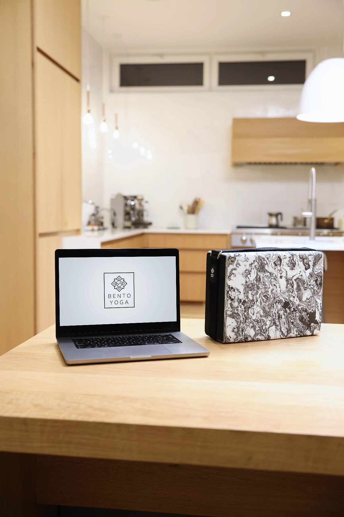 A laptop displaying Bento Yoga beside the closed ONE kit
